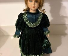 Vintage porcelain doll in green velvet dress