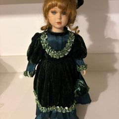 Vintage porcelain doll in green velvet dress