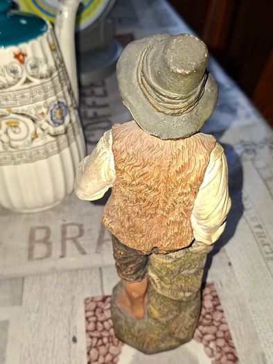 Old Painted Terracotta of a Young Country Boy Holding a Flute, standing on a rocky base. It resembles late 19th- or early 20th-century European decorative sculptures, such as pieces produced by makers like Goldscheider