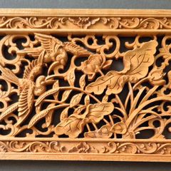 Carved decorative wooden panel, featuring birds.