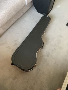 Hard case for bass guitar with storage compartment