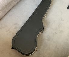 Hard case for bass guitar with storage compartment