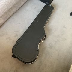 Hard case for bass guitar with storage compartment
