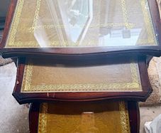 A vintage glass-protected, gold-tooled, leather top nest of tables