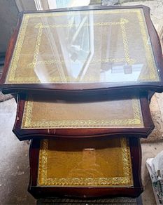 A vintage glass-protected, gold-tooled, leather top nest of tables