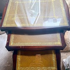 A vintage glass-protected, gold-tooled, leather top nest of tables