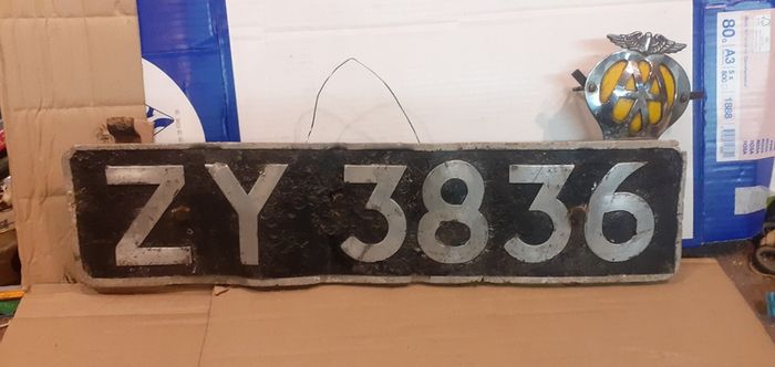 Vintage car number plate and aa badge