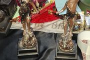A Pair of Antique French Spelter Statues titled La Force (The Strength) and Le Pouvoir (The Power). The feature a male and female figure standing a top lions, raising up flaming torches