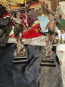 A Pair of Antique French Spelter Statues titled La Force (The Strength) and Le Pouvoir (The Power). The feature a male and female figure standing a top lions, raising up flaming torches