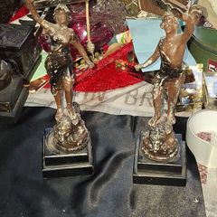 A Pair of Antique French Spelter Statues titled La Force (The Strength) and Le Pouvoir (The Power). The feature a male and female figure standing a top lions, raising up flaming torches
