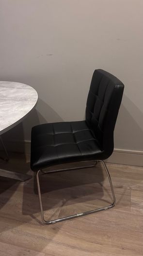 Round marble-effect dining table with 4 black chairs