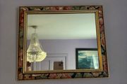 This vintage 1980s French mirror features a colorful floral pattern frame with distinct gold borders.