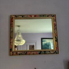 This vintage 1980s French mirror features a colorful floral pattern frame with distinct gold borders.