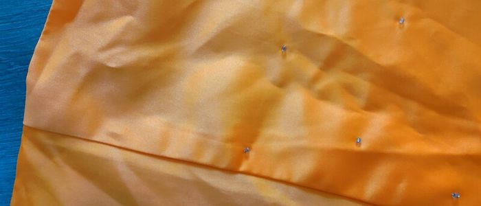 Solid orange satin look piece of fabric with beads