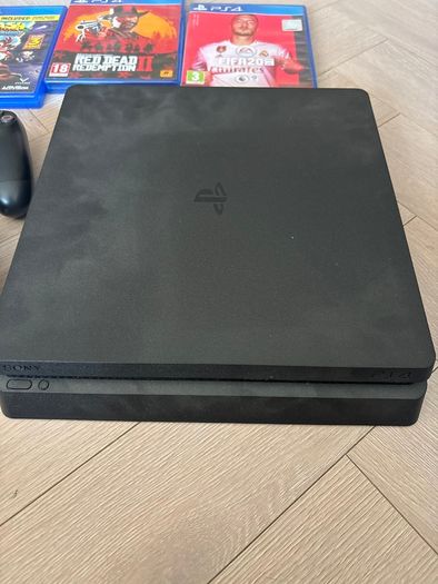 Sony PlayStation 4 console with two controllers and three games