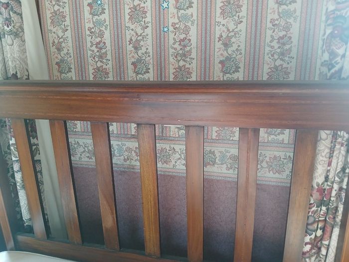 Wooden bed headboard and floral armchair