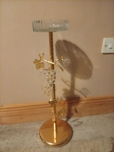 gold-finished, freestanding decorative stand features a clear glass top tray