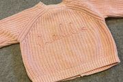 Tags on: Boutique branded pink baby cardigan with HELLO on back