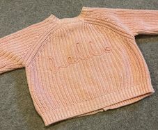 Tags on: Boutique branded pink baby cardigan with HELLO on back