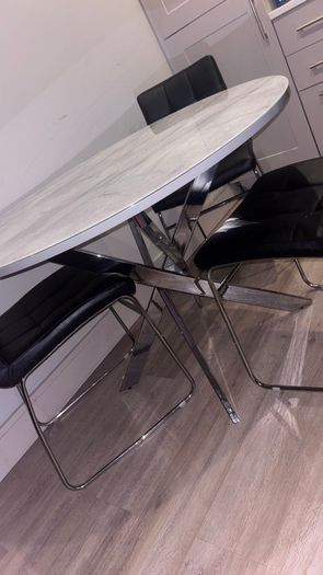 Round marble-effect dining table with 4 black chairs