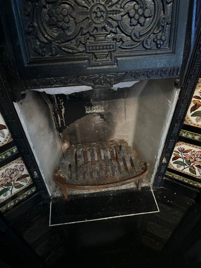 Victorian style cast iron fireplace with floral tiles