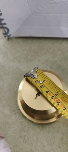 2 Papper Weight , Brass Papper Weight marked ISLAND 12.00 euro. Cleare Risen Tile Papper Weight.with black velvet on the back.10.00 euro.