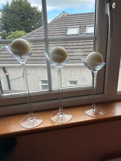 Set of 3 clear glass stemmed candle holders with ivory candles