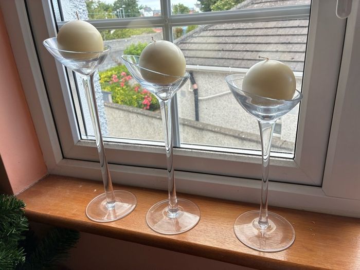 Set of 3 clear glass stemmed candle holders with ivory candles