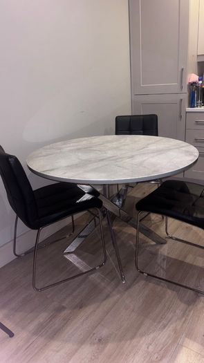 Round marble-effect dining table with 4 black chairs