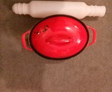 Red casserole cast iron pot with Tupperware rolling pin