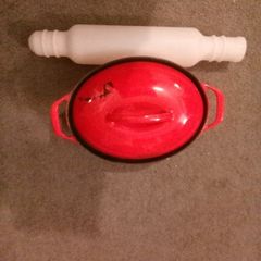 Red casserole cast iron pot with Tupperware rolling pin
