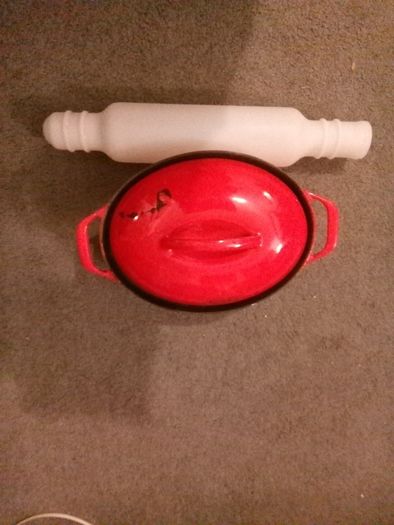 Red casserole cast iron pot with Tupperware rolling pin