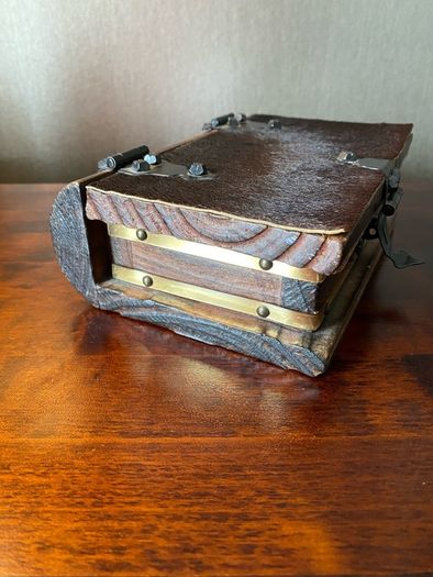 antique A wooden box in the form of a book, having brass escutcheon and black metal hinges. 18 x 15cm.