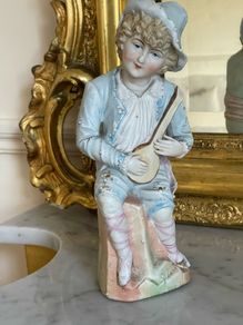 Antique bisque figure of young musician.