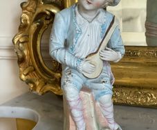 Antique bisque figure of young musician.