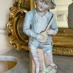 Antique bisque figure of young musician.