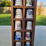 Collectible porcelain thimbles in a wall-mounted wooden display case Image 3