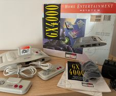 Boxed Amstrad GX4000 console with 2 controllers, cables, inserts, and pack-in game