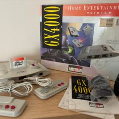 Boxed Amstrad GX4000 console with 2 controllers, cables, inserts, and pack-in game