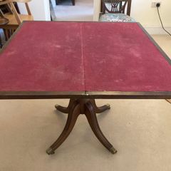 This is an antique mahogany fold-over card or games table with a red felt playing surface.