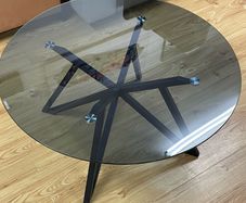 circular grey tinted glass coffee table with black metal base