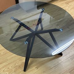 circular grey tinted glass coffee table with black metal base