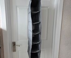 Grey fabric hanging closet organizer with 6 open shelves and side mesh pockets