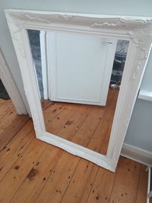 French Baroque/Rococo-style ornate wall mirror with a white painted molded frame