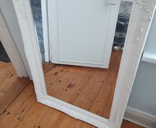 French Baroque/Rococo-style ornate wall mirror with a white painted molded frame