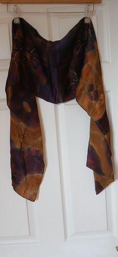 Hand painted, 100% silk scarf featuring a hand-rolled hem and custom metallic gutta detailing.