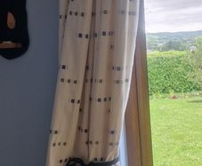 cream heavy curtains with ble & green pattern