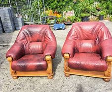 Two large wooden and leather armchairs