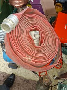 Coiled Red Canvas Fire Hydrant Hose with aluminium coupling and internal fitting visible at centre