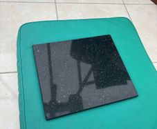 Two black granite chopping boards or heat boards
